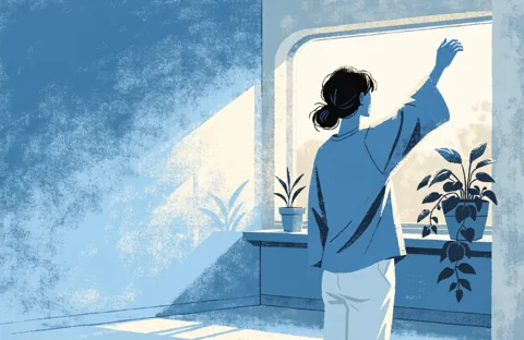 A person seen from behind, by a bright window, slowly raising one arm in a room with plants.
